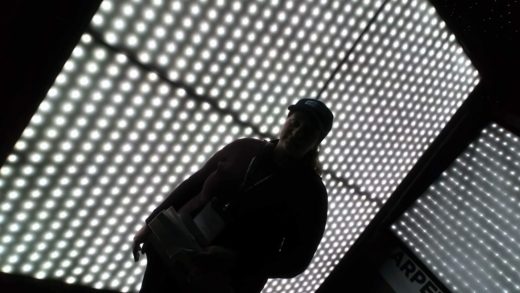 Woman standing in front of a hanging textile light with integrated white LED emitters.