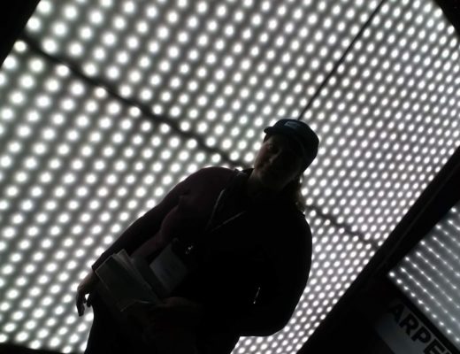 Woman standing in front of a hanging textile light with integrated white LED emitters.