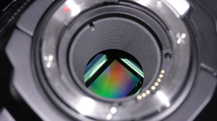 Closeup of the sensor in a Blackmagic Ursa Mini 4.6K camera. The sensor surface appears as a rainbow-coloured rectangle.