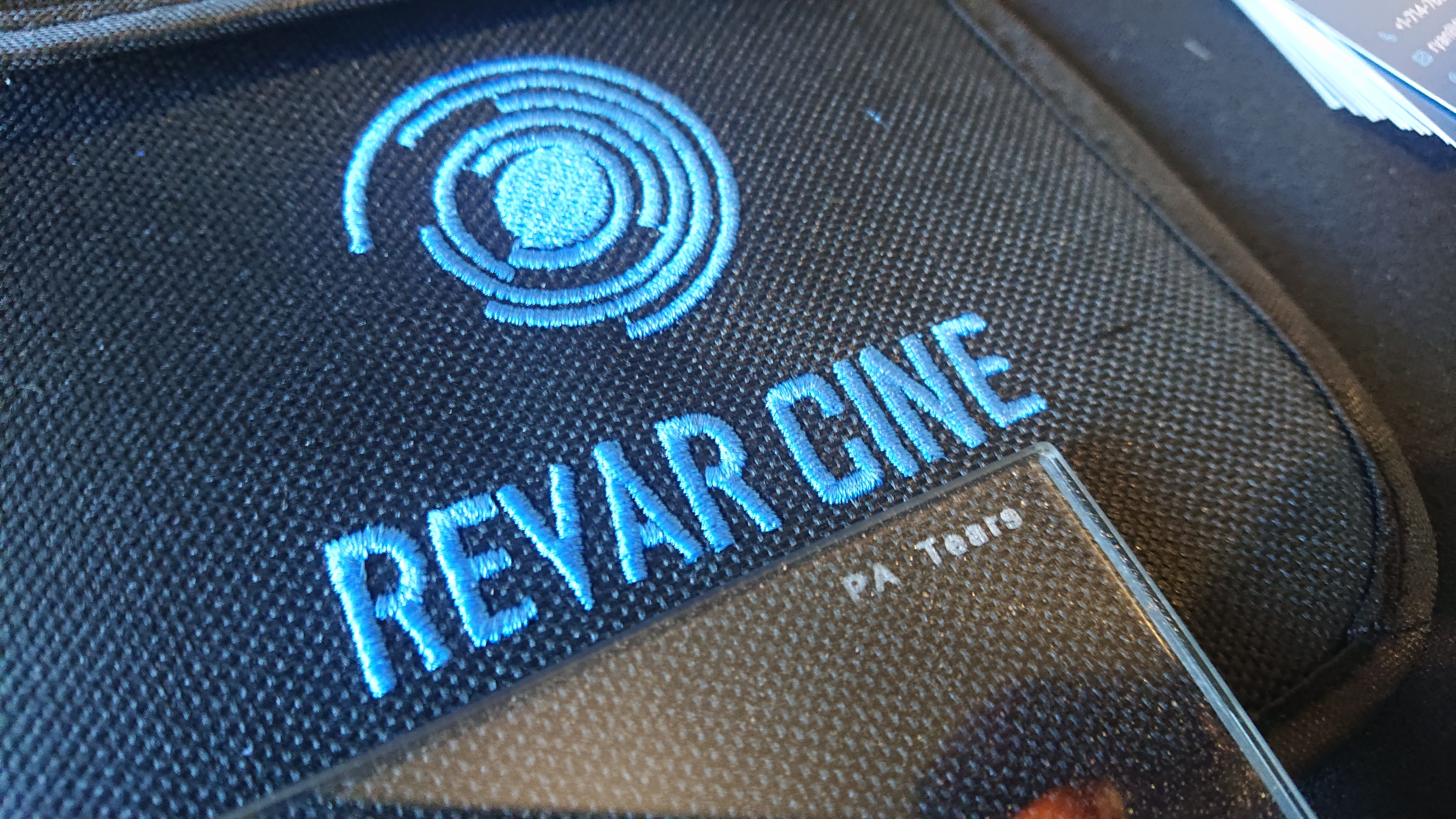 Closeup of a camera filter marked PA Tears lying on a Revar Cine filter pouch. Reflective flakes are visible in the structure of the filter.