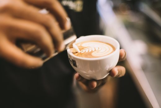 A nicely-made cup of coffee with pretty patterns in the foam.