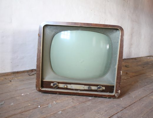 An old-style cathode ray tube TV, covered in spider webs.